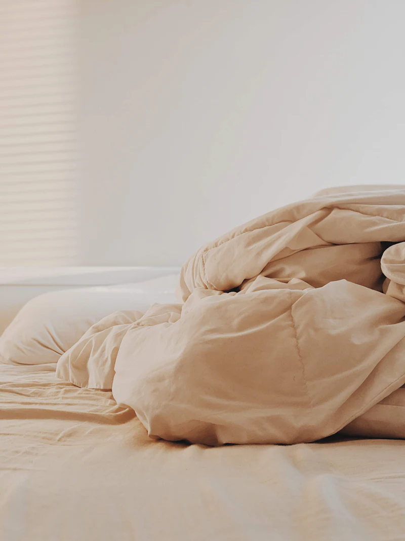 A soft comforter folded on a freshly made bed